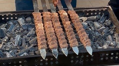 سیخ‌های کباب ایرانی در حال پخت روی زغال